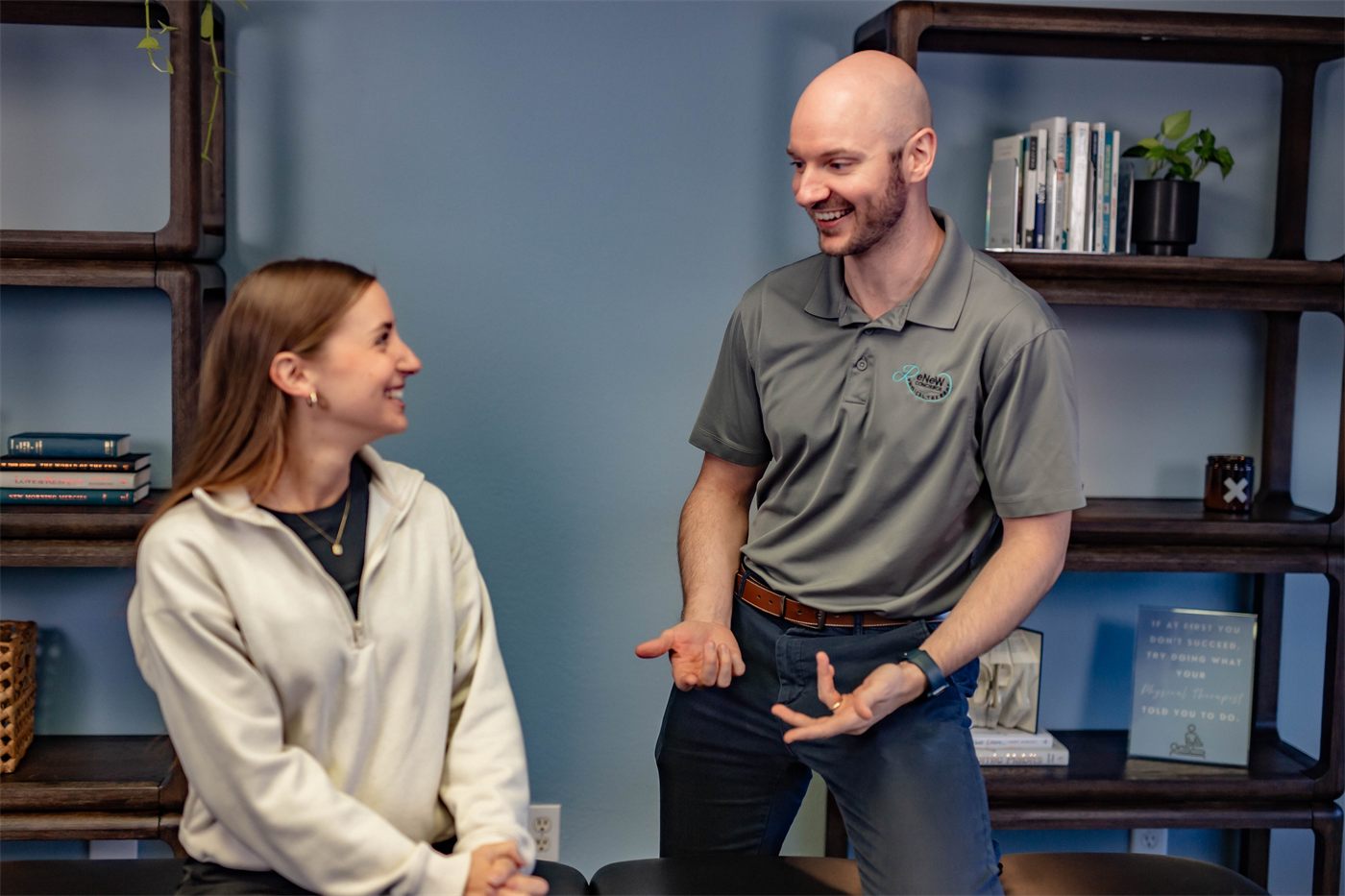 Dr. Ian Berry talking with a smiling patient during an evaluation at Renew